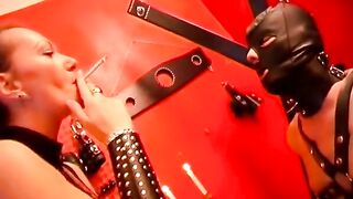 Two Mistresses Playing with Their Slave in the BDSM Dungeon